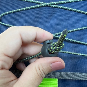 Eine Hand hält den Spanner an der Staumöglichkeit auf dem Deckel fest