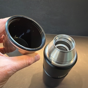 Eine Hand hält den Trinkbecher der Thermos Edelstahl Stainless King fest