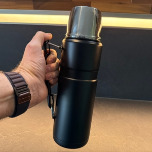 Die Thermos Edelstahl Stainless King wird von einer Hand am Griff festgehalten