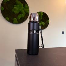 Die Thermos Edelstahl Stainless King vor einer grünen Wand