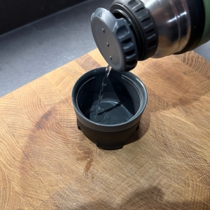 Wasser wird in den Trinkbehälter der Thermos Mountain gegossen