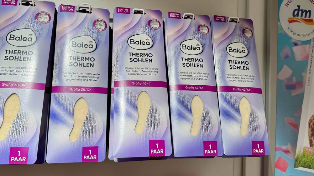 Mehrere getestete Thermosohlen hängen in einem Verkaufsregal.