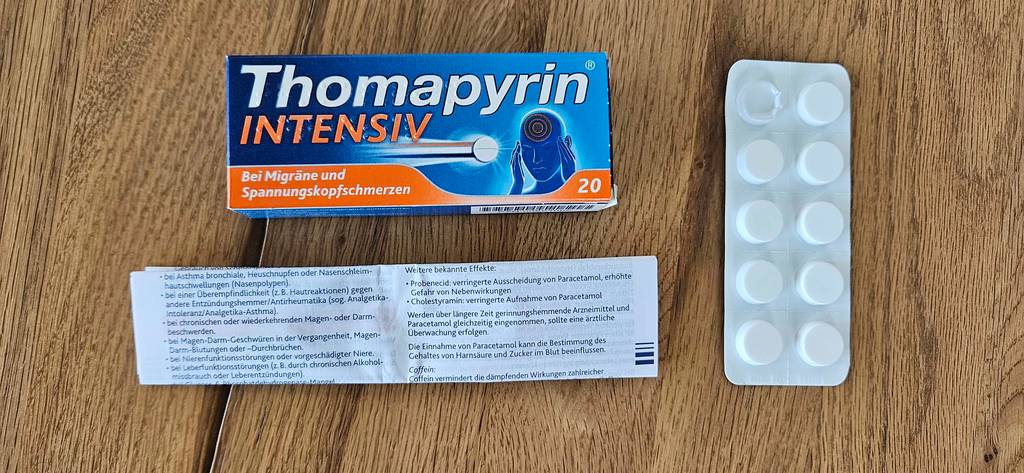 Migräne-Tabletten von Thomapyrin im Test: Verpackung liegt auf dem Holztisch.