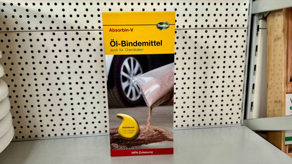 Im Test: Eine Packung Ölbindemittel steht in einem Lochwandregal.