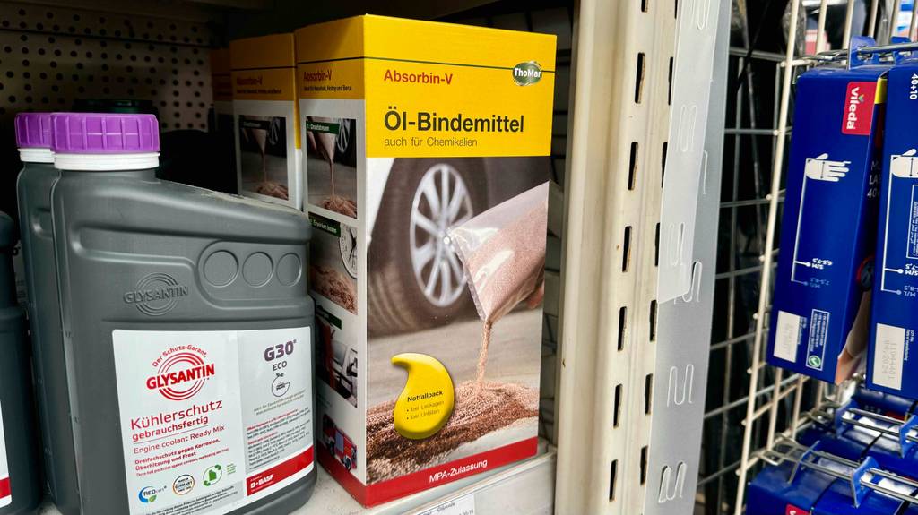 Eine Packung Ölbindemittel steht neben einem anderen Produkt zum Testen in einem Regal.