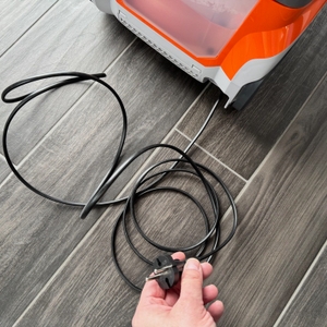 Eine Hand hält das Kabel des Thomas Pet and Family Aqua+