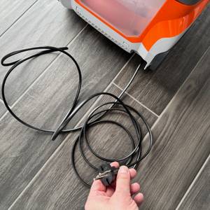 Eine Hand hält das Kabel des Thomas Pet and Family Aqua+