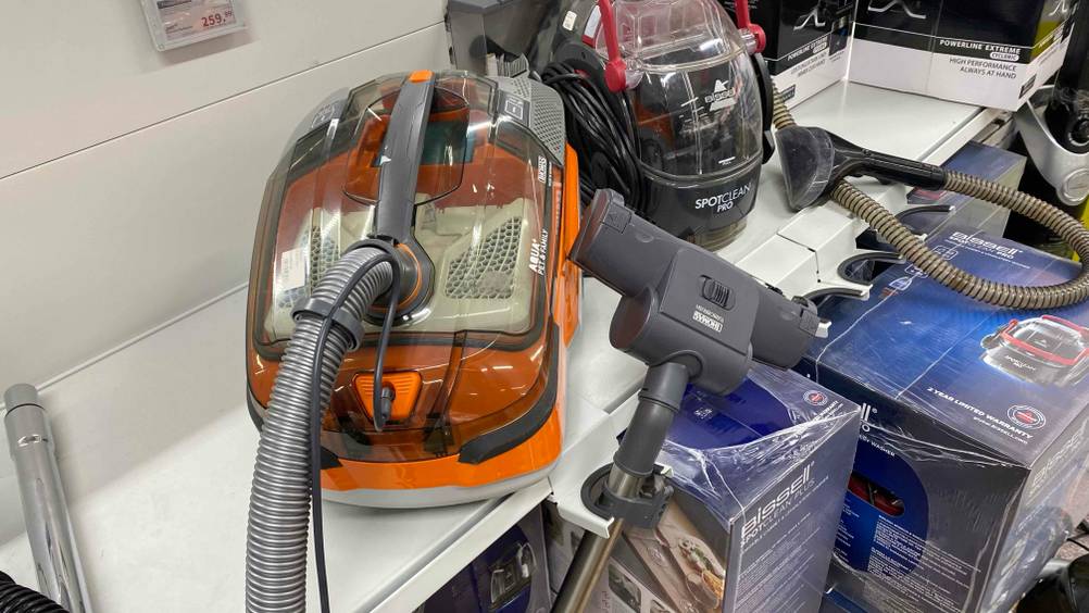 Wasserstaubsauger getestet: Ein Gerät von vorne mit Saugbürste im Hintergrund andere Geräte.