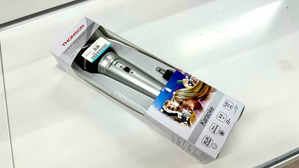 Ein dynamisches Mikrofon liegt zum Testen in seiner Originalverpackung auf einer weißen Fläche.