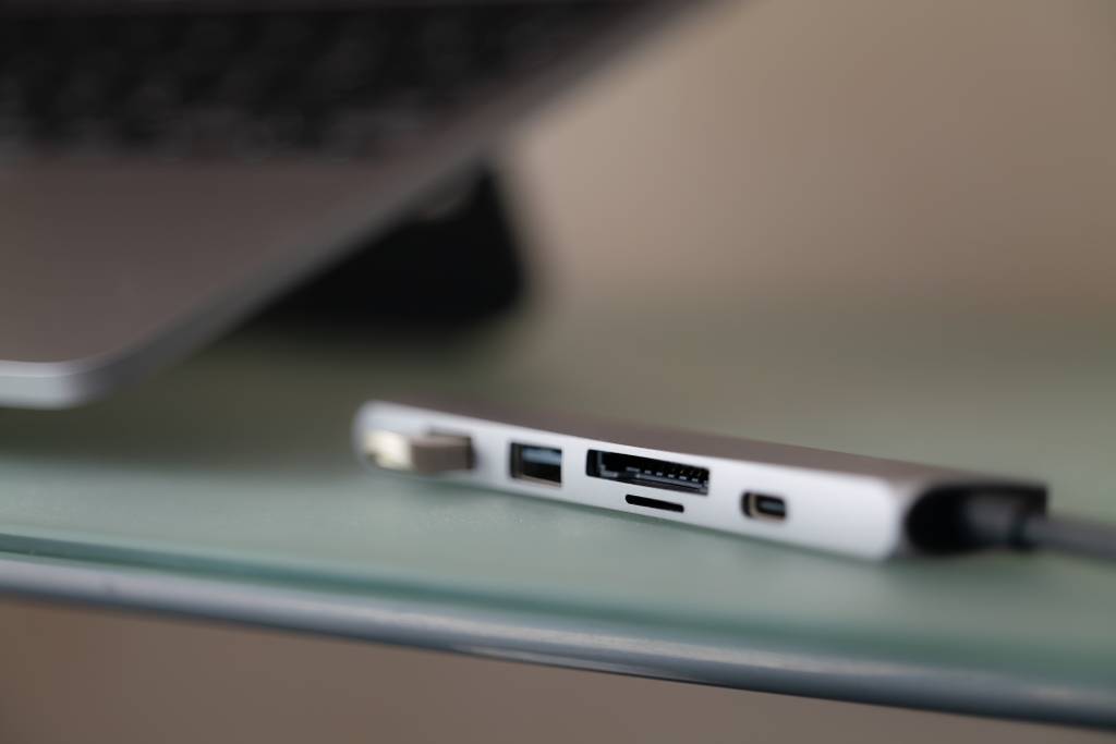 Thunderbolt-3-Dock im Test: Ein Dock mit diversen Ports und einem Stick, der ganz links eingesteckt ist. Verschwommener Hintergrund.