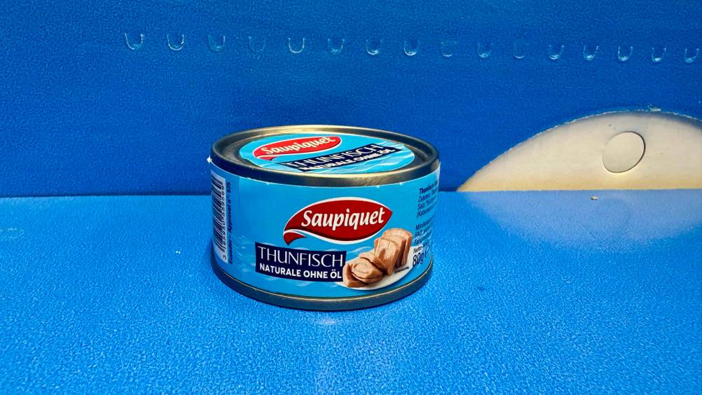 Thunfisch getestet: Eine Dose von der Seite auf und vor einer blauen Fläche.