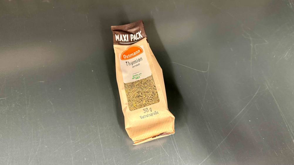 Auf einer grauen Fläche liegt eine Packung des getesteten Thymians.