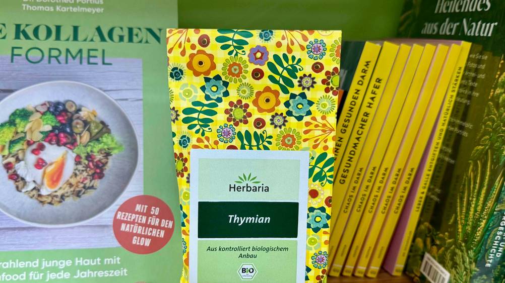 Thymiantee getestet: Nahaufnahme der Verpackung mit Logo und Artikelbezeichnung in einem Regal vor Büchern.