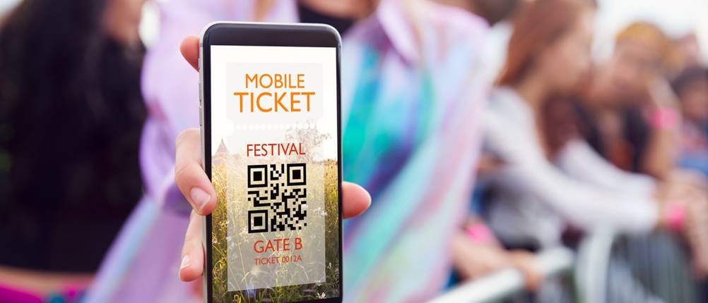 Festivalbesucher zeigt Mobile Ticket mit QR-Code auf dem Smartphone.