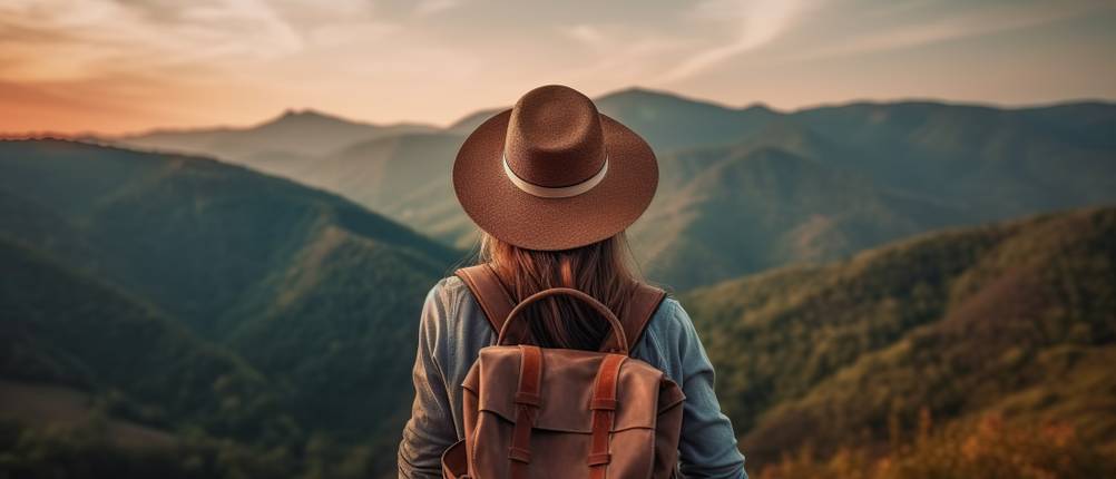Tilley-Hut im Test: Wanderin mit Rucksack steht vor Bergkulisse.