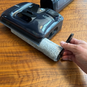 Eine Hand setzt eine Rolle in den Tineco Floor One S7