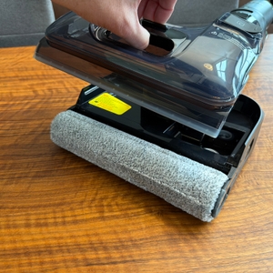 Eine Hand entfernt einen großen Behälter vom Tineco Floor One S7