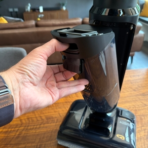 Eine Hand entfernt einen Behälter vom Tineco Floor One S7