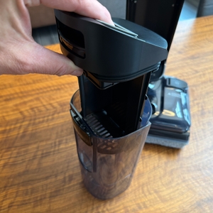 Eine Hand nimmt einen Filter aus einem Behälter vom Tineco Floor One S7