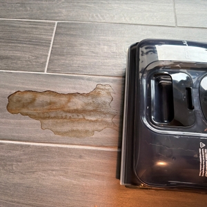 Ein Fliesenboden mit einem braunen Fleck wird mit dem Tineco Floor One S7 gereinigt