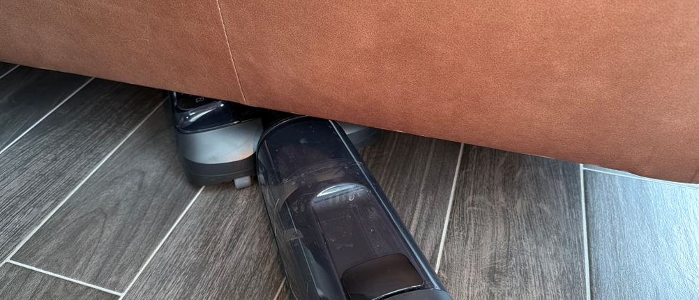 Mit dem Tineco Floor One S7 wird unter einer Couch gesaugt
