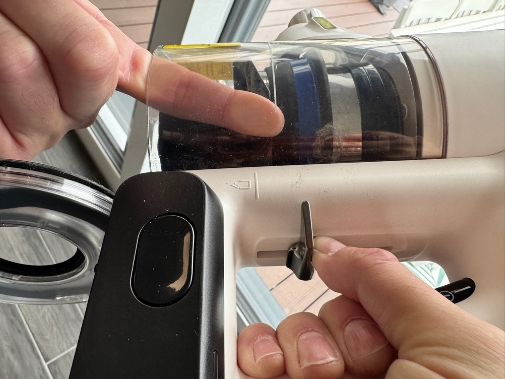 Ein Finger im Behälter des Tineco Pure One S15 Pet