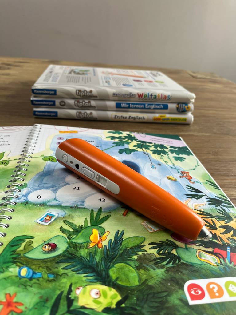 Ein Tiptoi-Stift im Test liegt auf einem geöffneten Buch.
