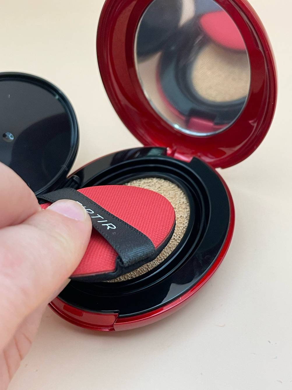 Eine Hand streicht mit dem Pad über den getesteten Foundation-Puder.