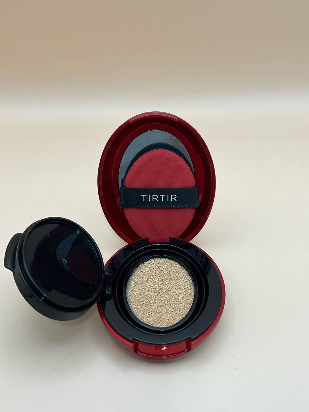 Blick von oben auf einen geöffneten Tiegel mit Foundation-Puder zum testen.