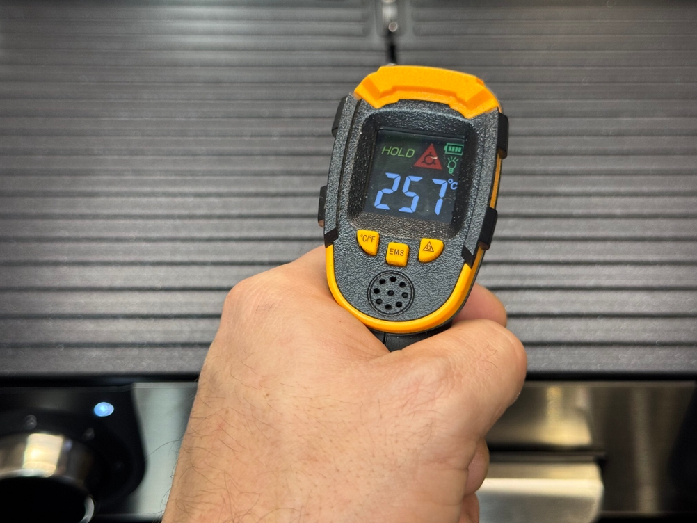 Eine Person misst im Test die Temperatur des WMF-Tischgrills.