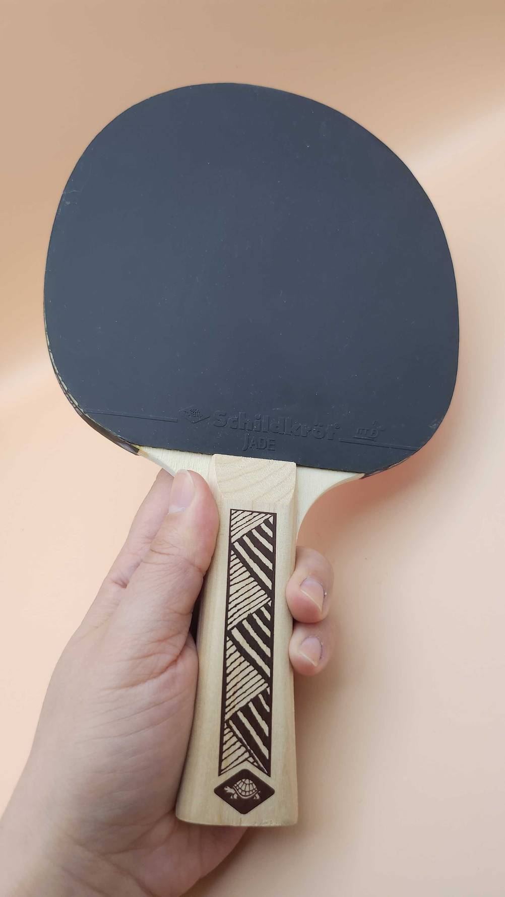 Tischtennis-Holz getestet: Eine Hand hält den Schläger.