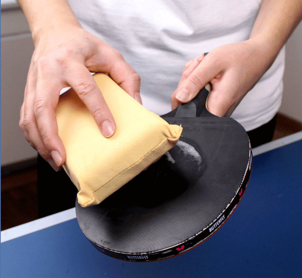 Tischtennisschläger-Test: Ein Tischtennisschläger wird mit einem Schwamm gereinigt.