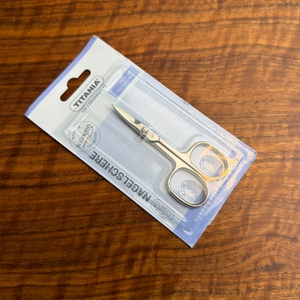 Die Verpackung der Titania-Nagelschere liegt auf einem Tisch.