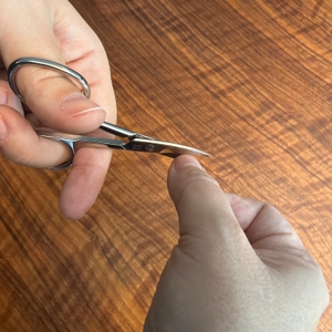 Mit der Titania-Nagelschere wird ein Fingernagel geschnitten.