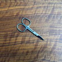 Die Titania-Nagelschere liegt auf einem Holztisch.