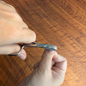 Ein Fingernagel wird mit der Titania-Nagelschere geschnitten.