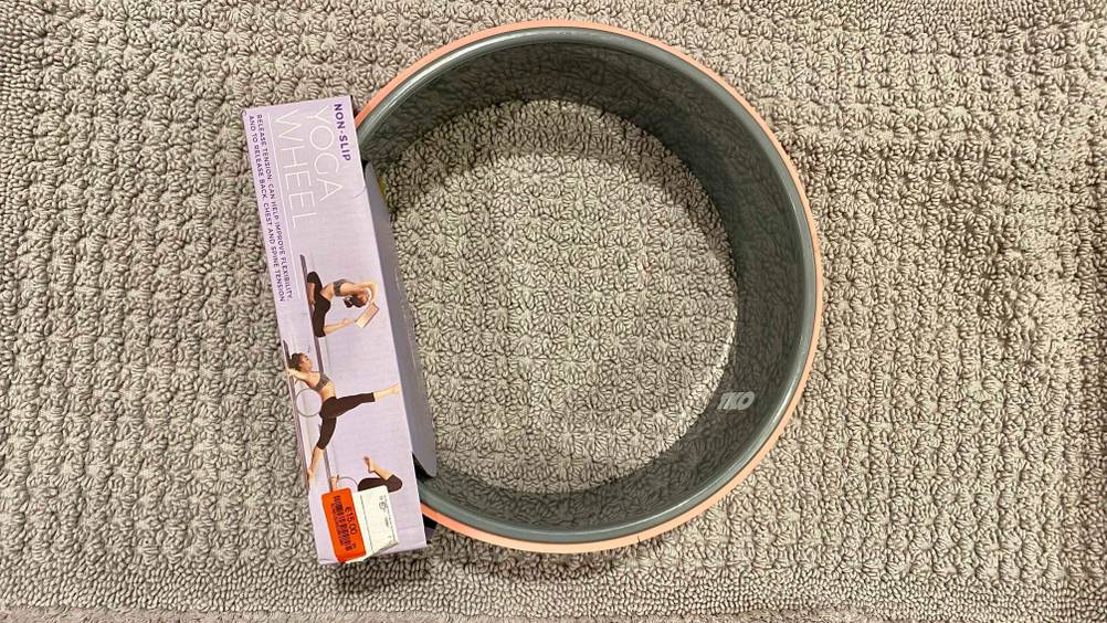 Yoga Wheel getestet: Ein auf der Seite liegendes Gerät verpackt von oben auf einem grauen Handtuch.