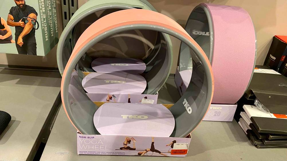 Yoga-Wheel-Test: Mehrere verpackte Yoga Wheels stehen nebeneinander in einer Verkaufsfläche neben anderen Produkten.