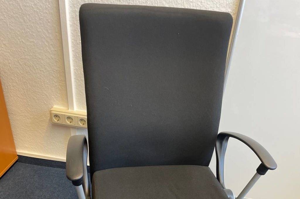 Bürostuhl-Test: Ansicht von schräg oben eines schwarzen Modells to-strike comfort pro (SK 9248/pro) von Dauphin, der auf einem blauen Teppich steht.
