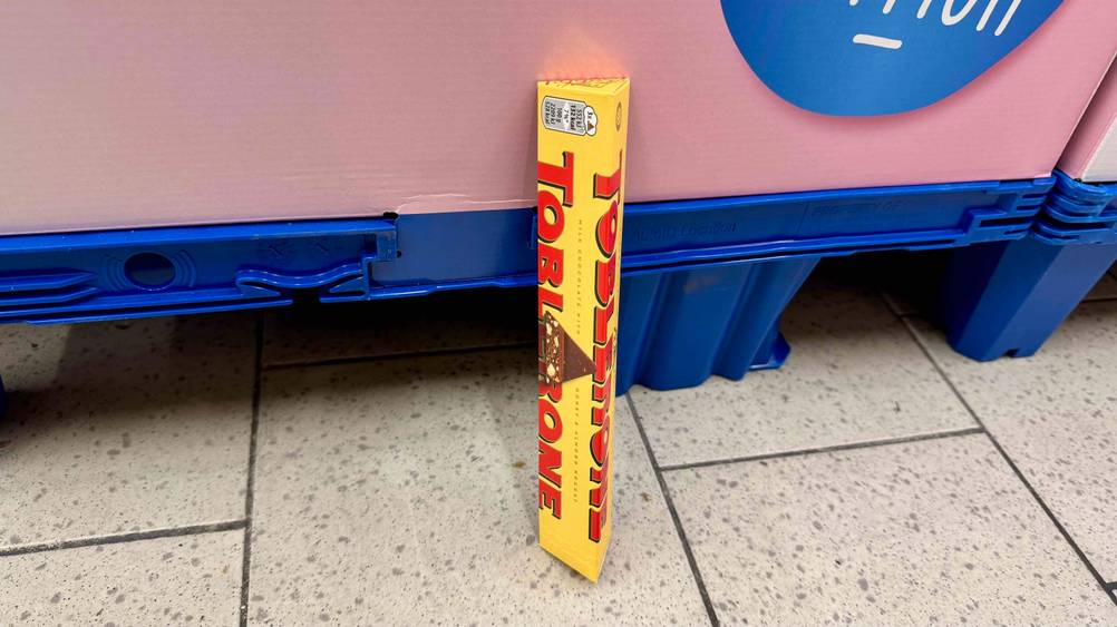 Eine getestete Toblerone lehnt an einer blauen Palette.