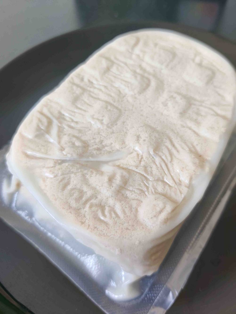 Ein getesteter Tofu-Block befindet sich verpackt auf dem Tisch. 