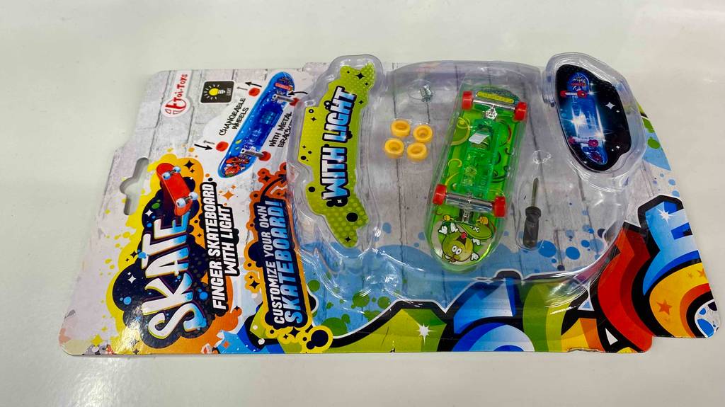 Finger-Skateboard im Test: Finger-Skateboard befindet sich in seiner durchsichtigen Originalverpackung auf einer hellen Oberfläche.