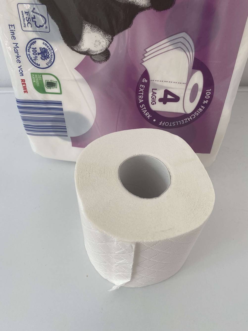 Ein getestetes 4-lagiges Toilettenpapier befindet sich vor der Verpackung. 