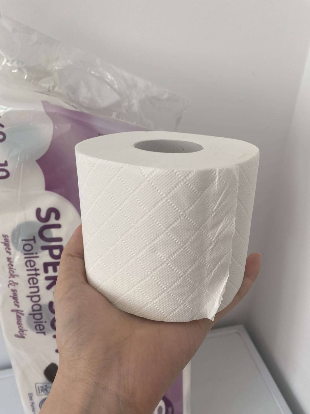 Ein Hand hält ein getestetes 4-lagiges Toilettenpapier.