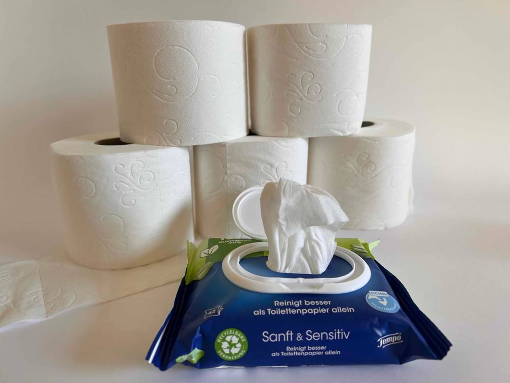 Toilettenpapier getestet: Mehrere Rollen aufeinander, davor eine geöffnete Packung feuchtes Toilettenpapier.