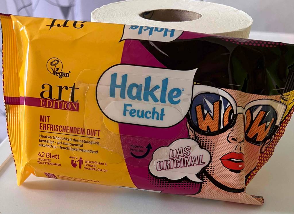 Eine getestete Toilettenpapier-Packung liegt an einer Toilettenrolle an. 