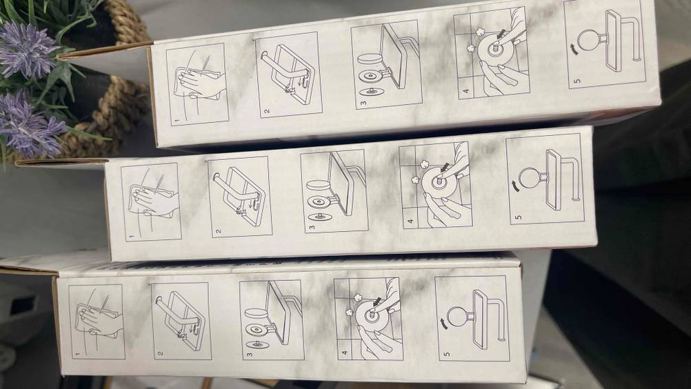 Toilettenpapierhalter im Test: Nahaufnahme der Grafiken auf der Seite der übereinander gestapelten Packungen.