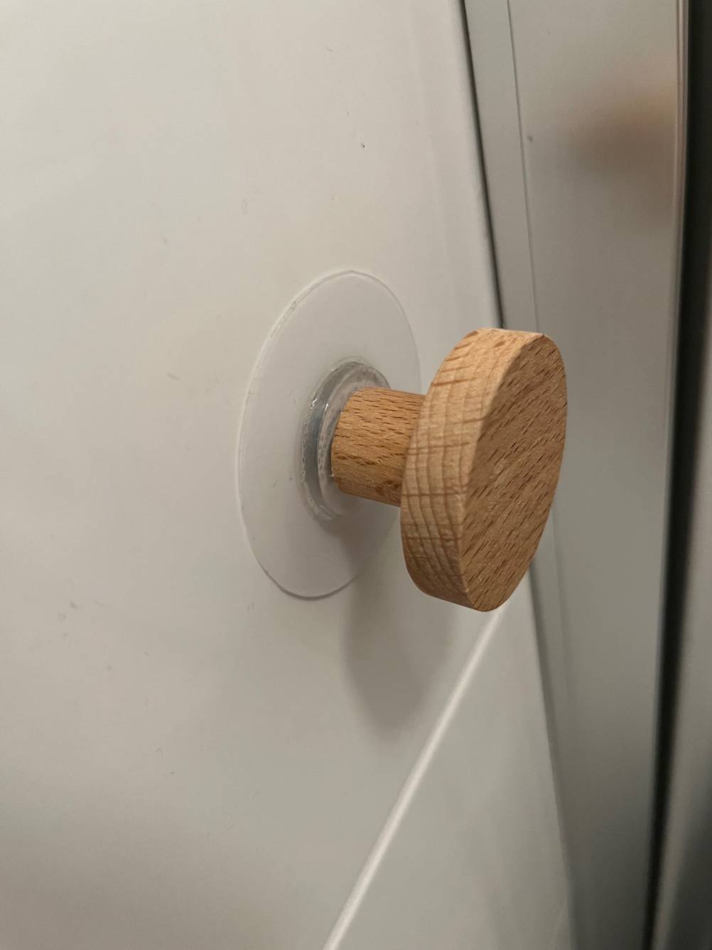 Toilettenpapierhalter ohne Bohren im Test: Nahaufnahme des Saugnapf mit Knopf.