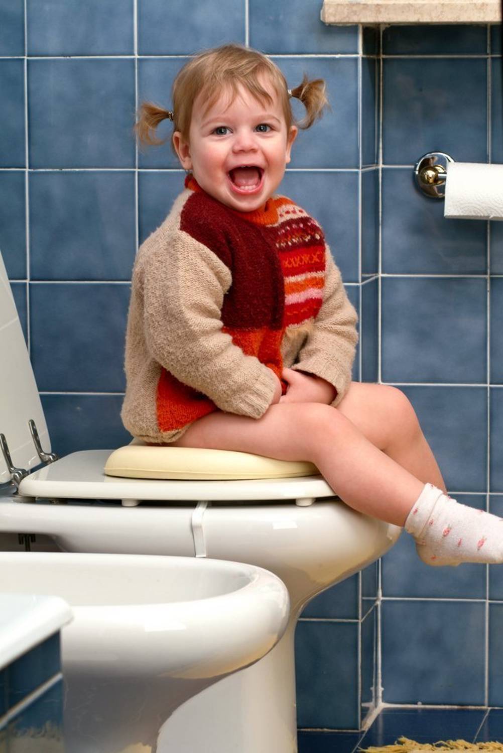 Kinder-Toilettensitz im Test: Dieses kleine Mädchen hat sichtlich Spaß auf der Toilette.