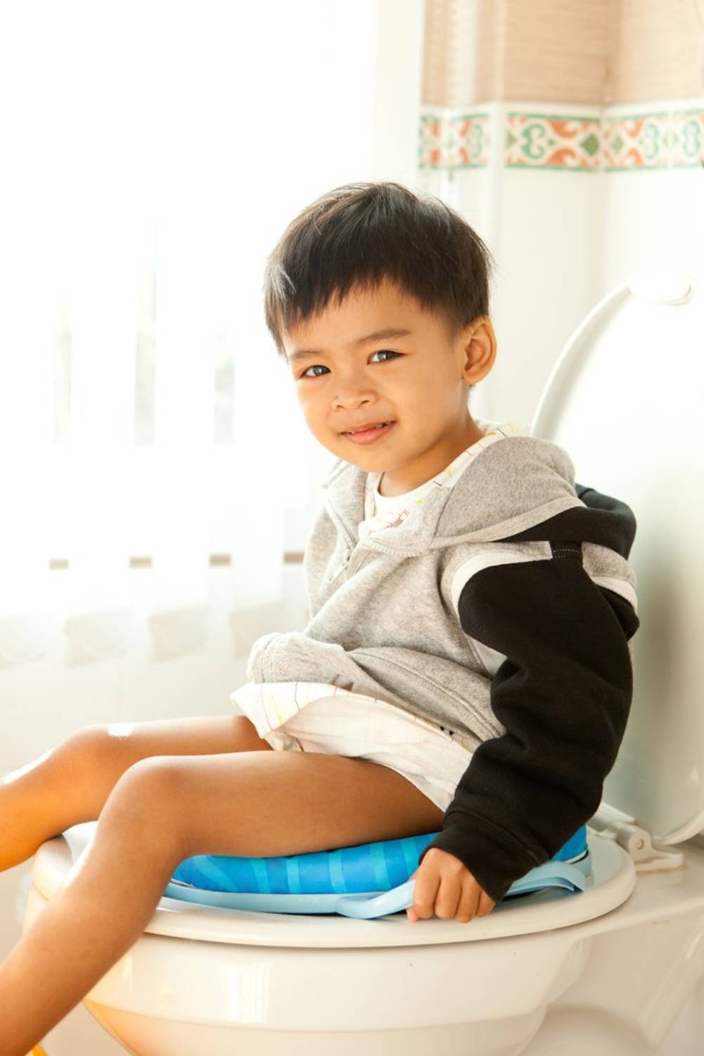 Kinder-Toilettensitz im Test: Ein Junge mit einem blauen Sitz